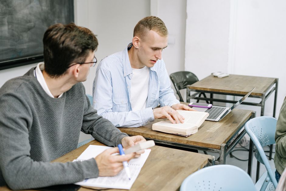 Laptop mit Kopfhörern und Notizbuch auf einem Tisch